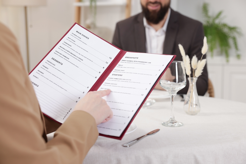 Cliente leyendo carta impresa en carpeta de menú - Megaprint imprime menús para restaurantes en toda la República Mexicana