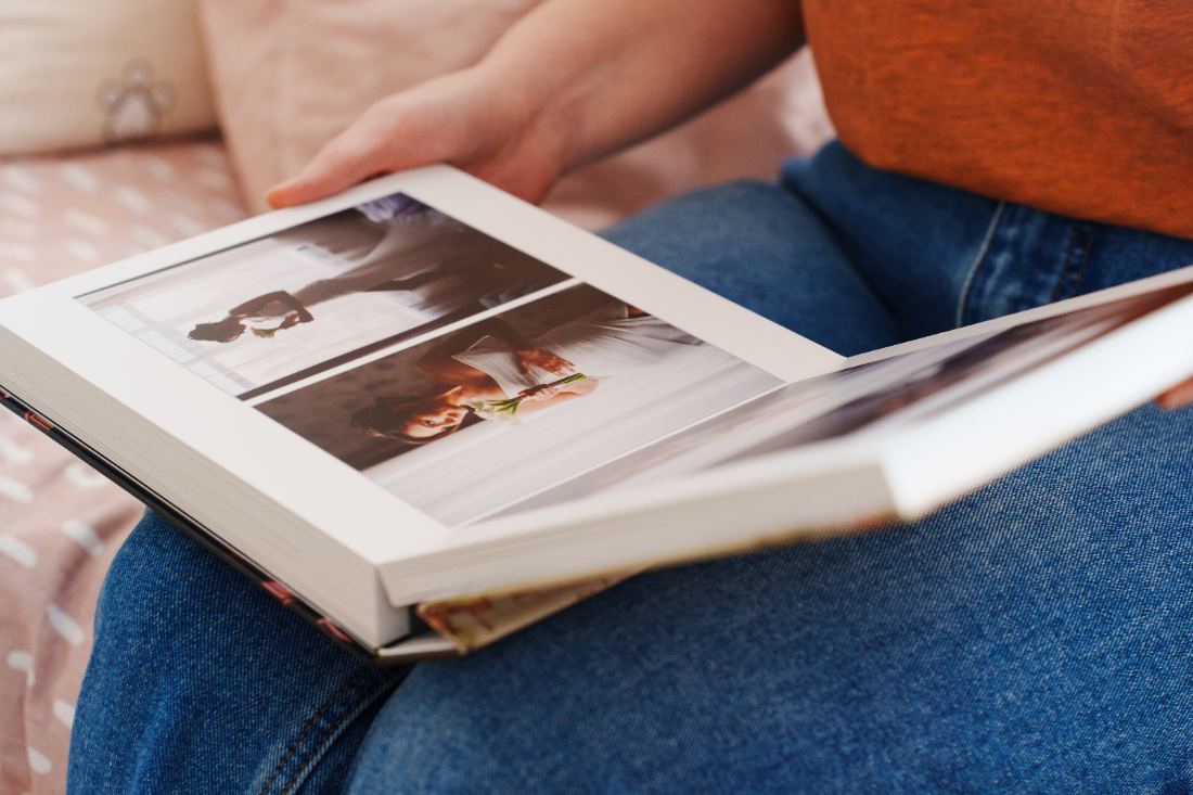 Manos hojeando un álbum familiar con fotografías impresas en papel fotográfico