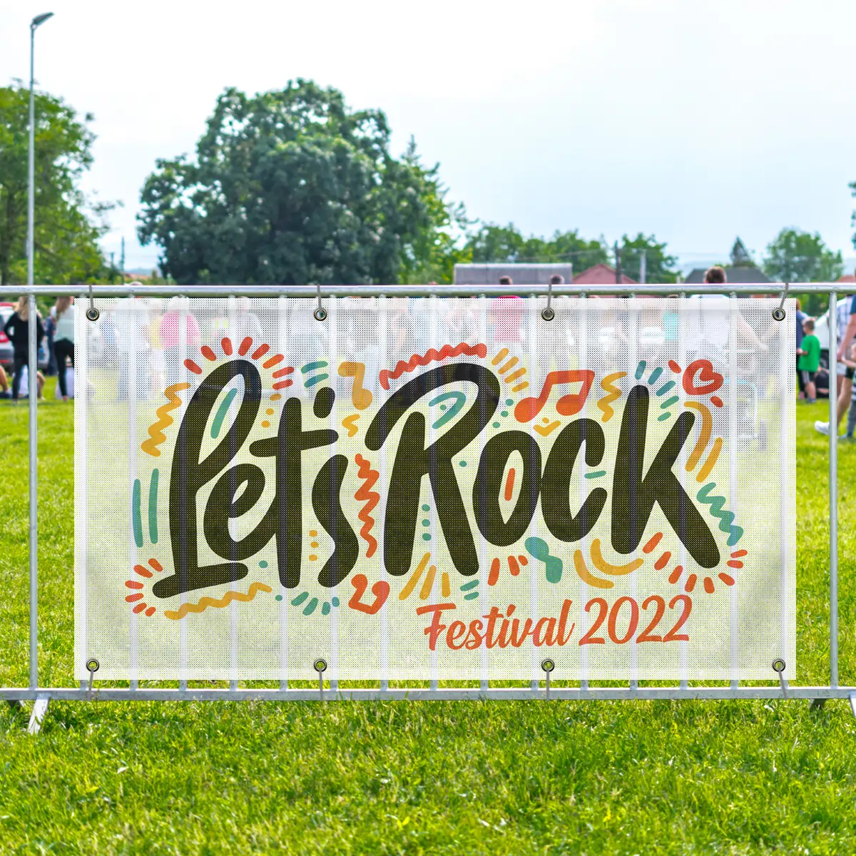 Mesh banner installed on outdoor fencing at a festival